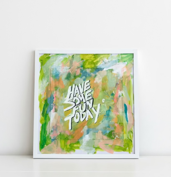 Framed abstract painting with colorful brushstrokes and text 'HAVE SOME FUN TODAY!' on a wooden surface.