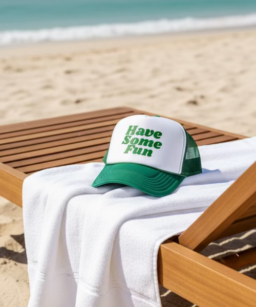 Green and white cap with 'Have Some Fun' text on a beige couch