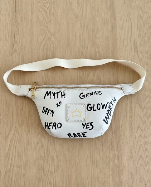 White fanny pack with motivational phrases on a fluffy white surface